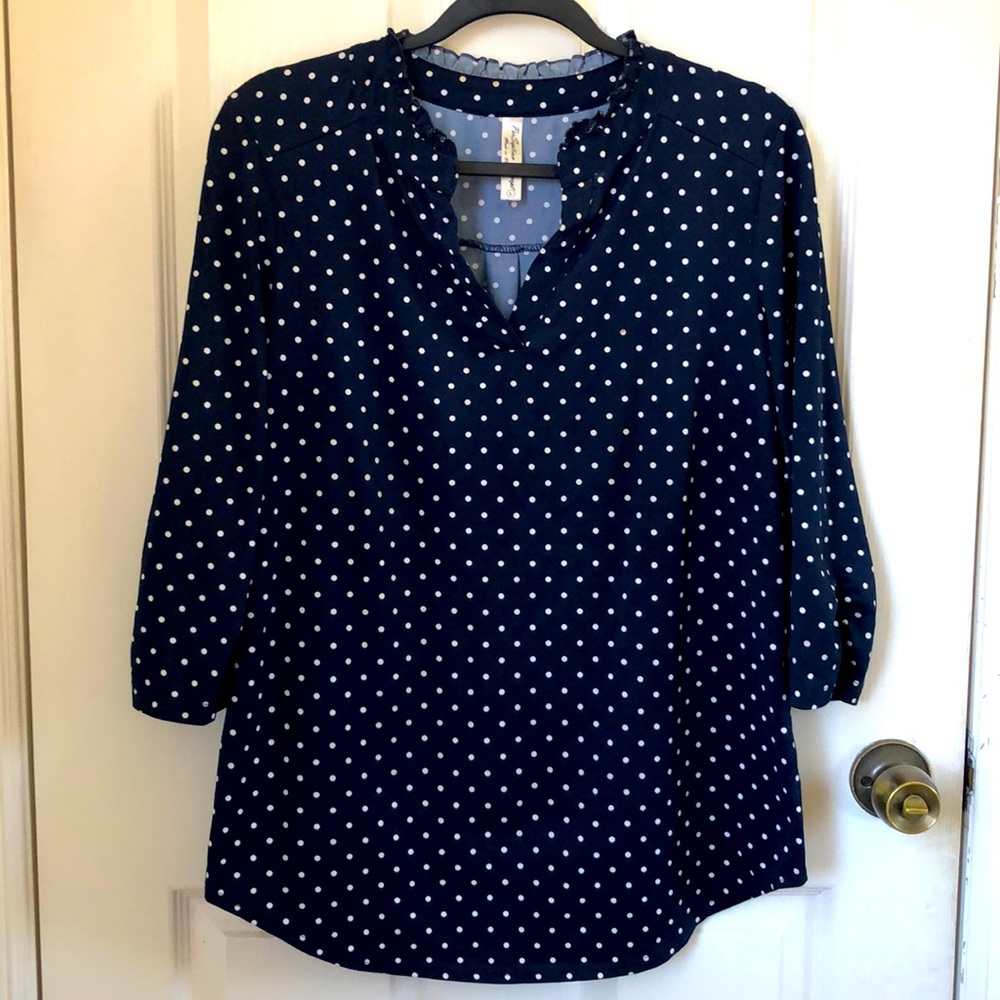 3/4 length blue and white polka-dot blouse.